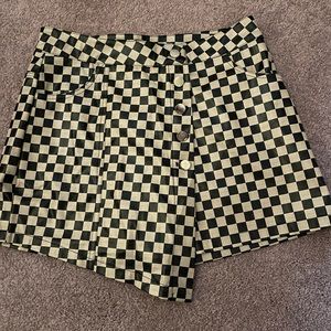 Vinyl A- Symmetric checkered skort. Has silver buttons and a zipper in the front
